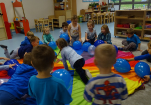 dzieci kładą balony chustę