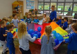 dzieci unoszą balony na chuście