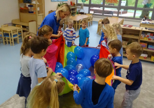 dzieci trzymają balony w chuście