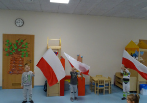 chłopcy trzymaja flagi