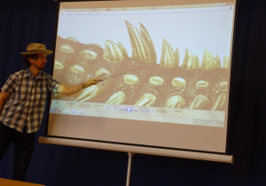 Paleontolog pokazuje dinozaura na prezentacji