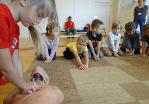 Dzieci ćwiczą wykonywanie masażu serca.