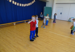 Dzieci tańczą w parach trzymając się za ręce.