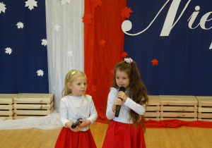 Dzieci recytują wiersz przez mikrofon.