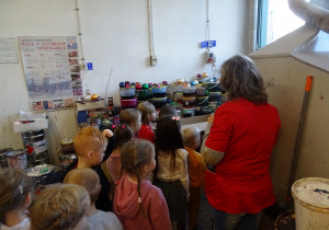 Dzieci oglądają pomieszczenie, w którym maluje się bombki.