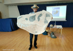 Paleontolog przeentuje głowę dinoaura.