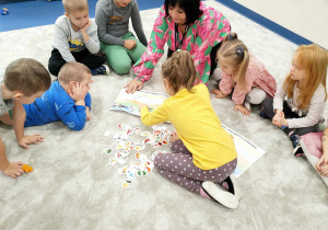 Dzieci wspólnie z nauczycielem układają produkty w piramidzie zdrowia.