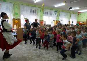 Tancerka uczy dzieci kroków tańca ludowego