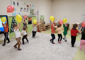 Dzieci trzymają baloniki nad głową
