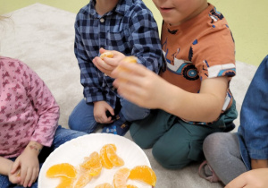 Dzieci częstują się pomarańczą