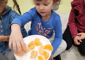 Dzieci częstują się pomarańczą