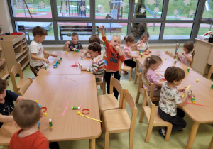 Dzieci wykonują łańcuch na choinkę z papieru