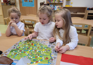 Dzieci grają w grę planszową o Polsce