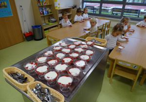 Dzieci jedzą biało czerwony deser