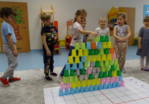 dzieci budują Wieżę Eiffla z kubków