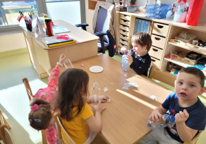 Dzieci wkładają do swoich buteleczek różne przedmioty