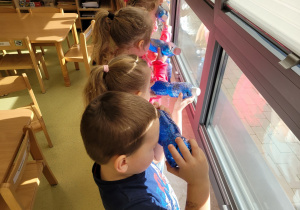 Dzieci oglądają butelki pod światło