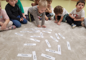 Dzieci wyszukują swoje imię spośród wszystkich wizytówek