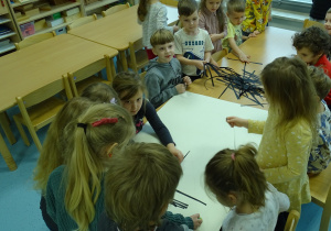 dzieci naklejają pajęczynkę