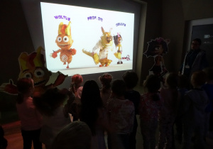 Dzieci oglądają postaci na ekranie.