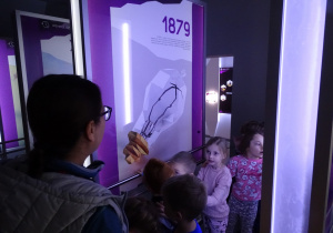 Dzieci patrzą na obraz żarówki.