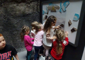 Dzieci układają puzzle na ścianie.