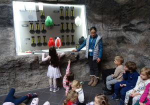 Dzieci oglądają czako górnicze i oznaczenia górników.