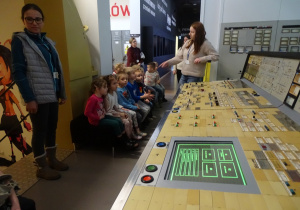 Dzieci oglądają makietę urządzenia do sterowania elektrownią.