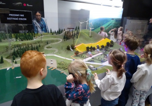 Dzieci oglądają makietę góry rekreacyjnej.