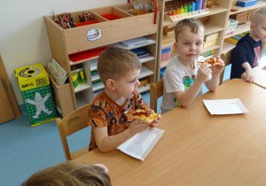 dzieci jedzą pizzę