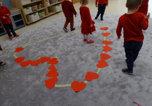 21 Dzieci układają na podłodze papierowe serca