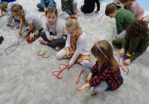 dzieci układają literę B ze sznurka