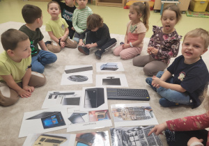 Dzieci oglądają ilustracje dawnych i współczesnych komputerów