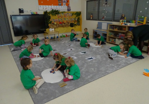 03 Dzieci w grupach ukladają puzzle z dinozaurami