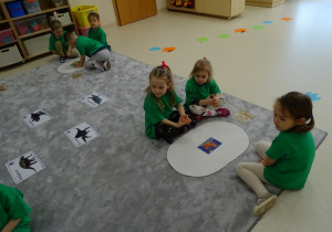 05 Dzieci siedzą przy dywanikach z obrazkiem