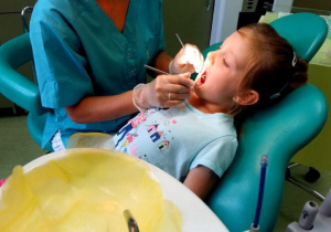 pani stomatolog bada ząbki dziecku