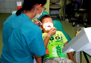 pani stomatolog bada ząbki dziecku