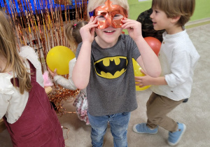 Dzieci przymierzają maski i akcesoria z fotobudki