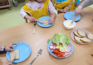 Dzieci smarują chlebek masłem
