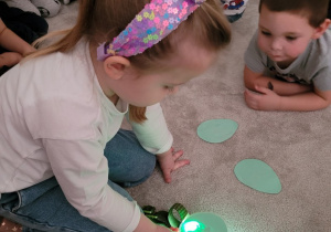 Dzieci podświetlają latarką jaja dinozaurów