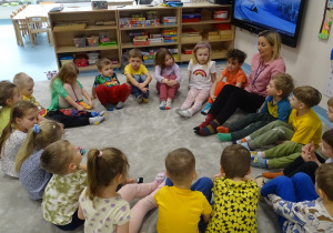 dzieci siedzą na dywanie i rozmawiają o swoich różnych skarpetkach