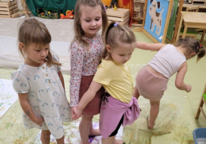Dzieci stoją na pomalowanej podłodze
