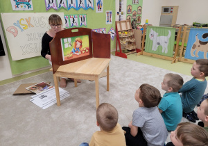 Dzieci oglądają ilustracje i słuchają opowiadania
