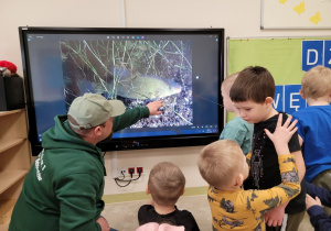 Dzieci oglądają wyświetlane zdjęcia ryb