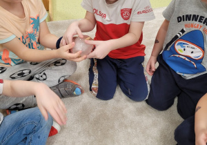 Dzieci podają sobie lodowe jajko