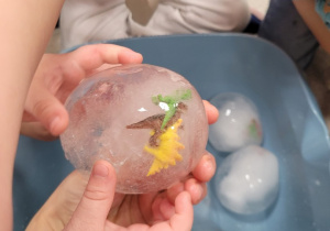 Figurki dinozaurów zatopione w lodowym jajku