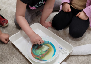 Dzieci doświadczają malowania na mleku