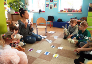 Nauczyciel pokazuje dzieciom misia w kolorze fioletowym