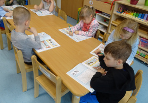 dzieci wykonują zadania w książce