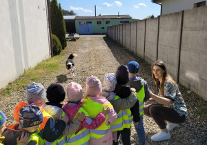 Dzieci stoją w kolejce do rzucania pieskowi patyka